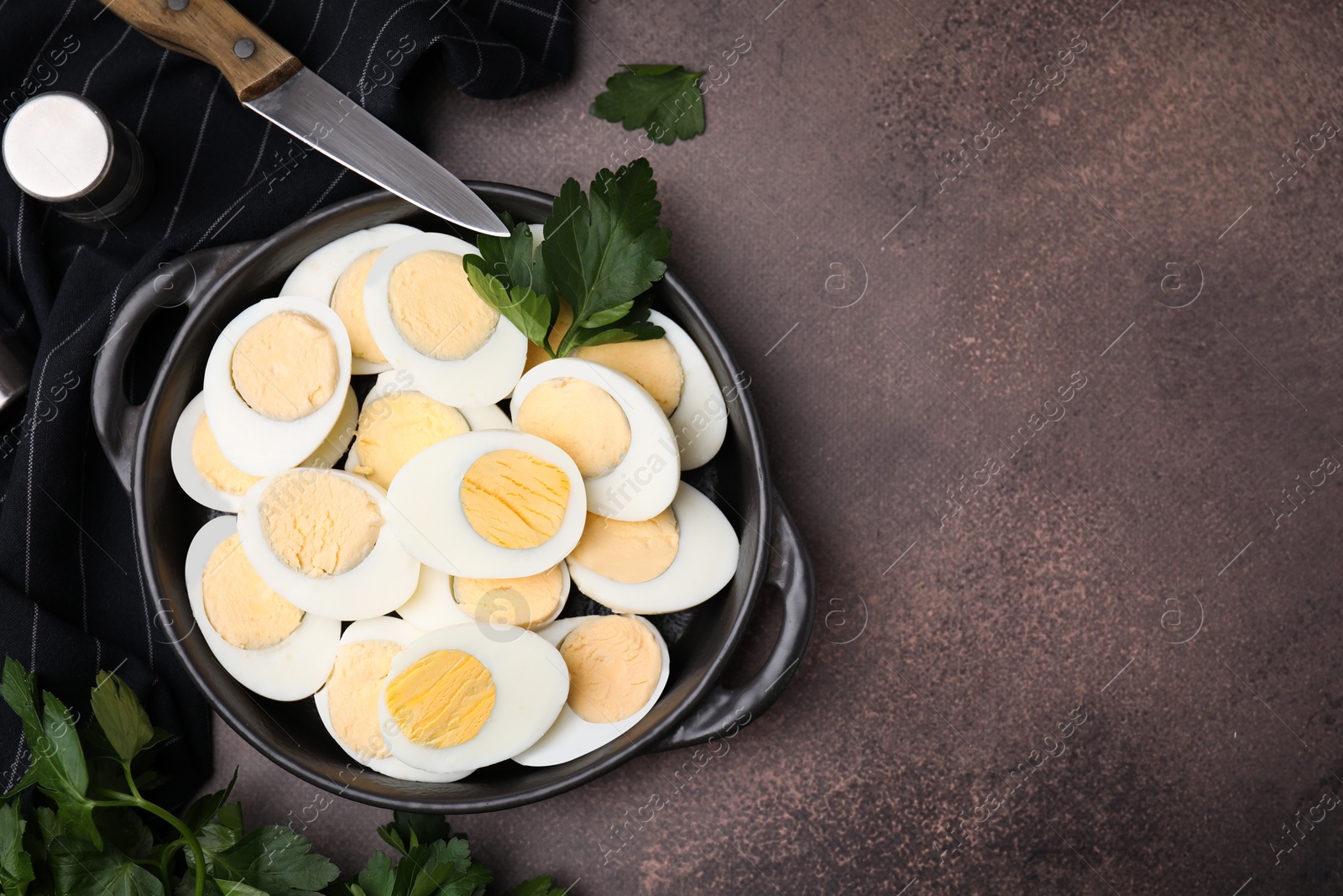 Photo of Fresh hard boiled eggs and parsley on brown table, flat lay. Space for text