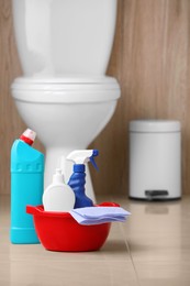 Photo of Different toilet cleaning supplies on floor indoors