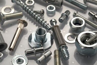 Photo of Many different fasteners on plastic surface, closeup