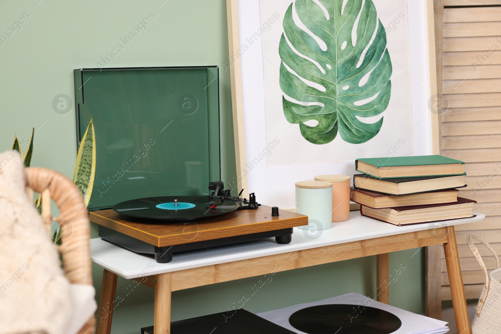 Photo of Stylish turntable with vinyl record on console table in room