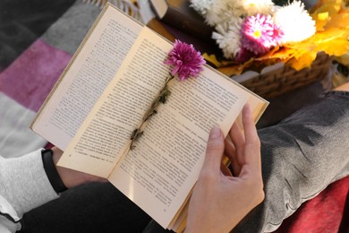 Photo of Woman reading book outdoors on autumn day, above view