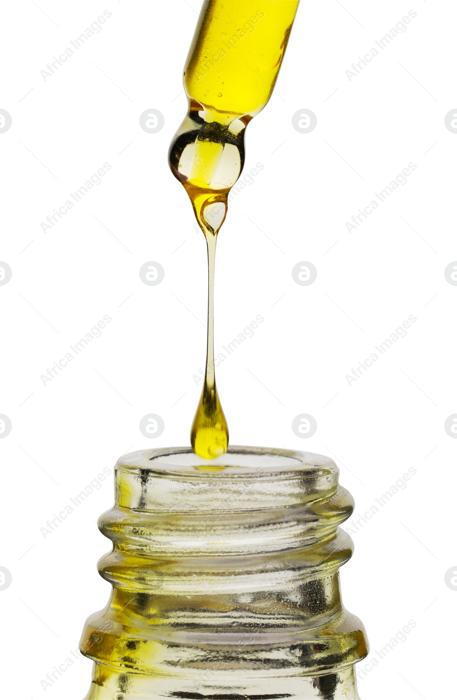 Photo of Dripping yellow facial serum from pipette into glass bottle on white background, closeup