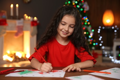 Photo of Little child drawing picture at home. Christmas celebration