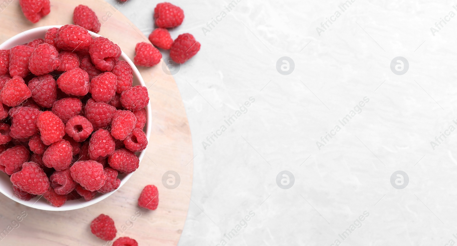 Photo of Delicious fresh ripe raspberries on light marble table, flat lay. Space for text