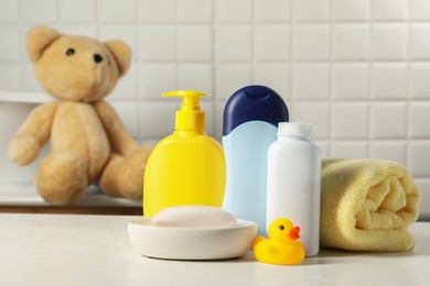 Photo of Baby cosmetic products, bath duck and towel on white table