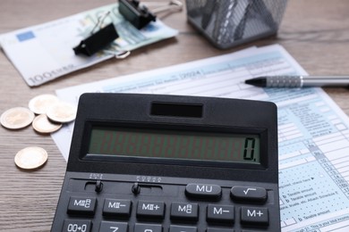 Photo of Tax accounting. Calculator, document, money and stationery on wooden table, closeup