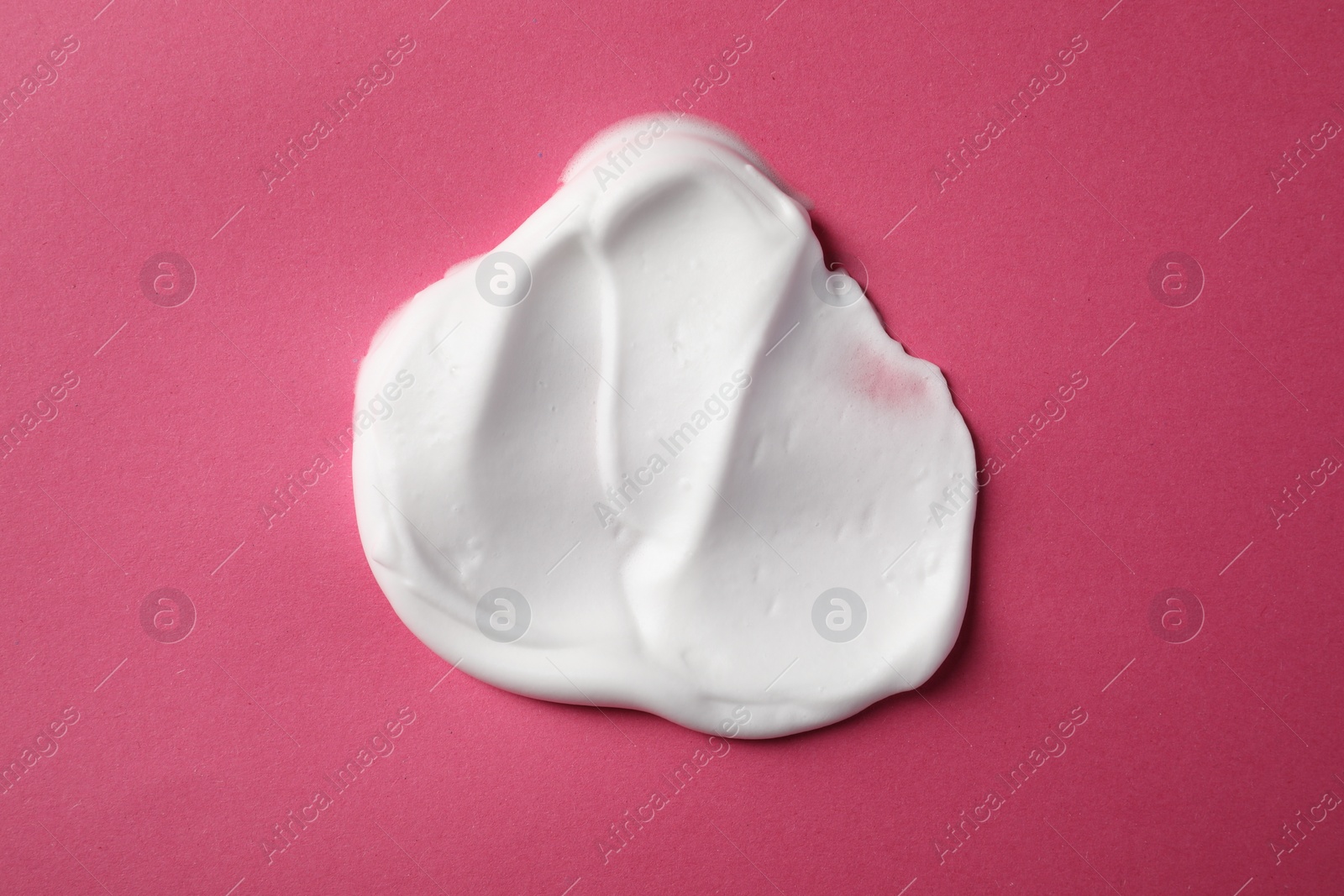 Photo of Sample of shaving foam on pink background, top view