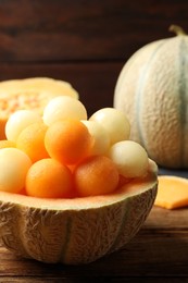 Photo of Many different melon balls on wooden table