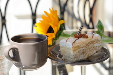 Photo of Tasty dessert, cup of fresh aromatic coffee and flower on glass table outdoors, closeup