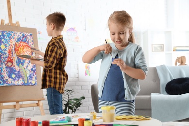 Photo of Cute little children painting together at home