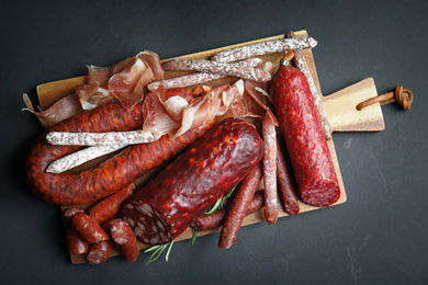 Photo of Different types of sausages served on black background, top view