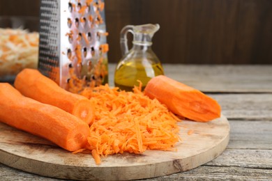 Photo of Cooking delicious sauerkraut soup. Fresh chopped carrot on wooden table, closeup