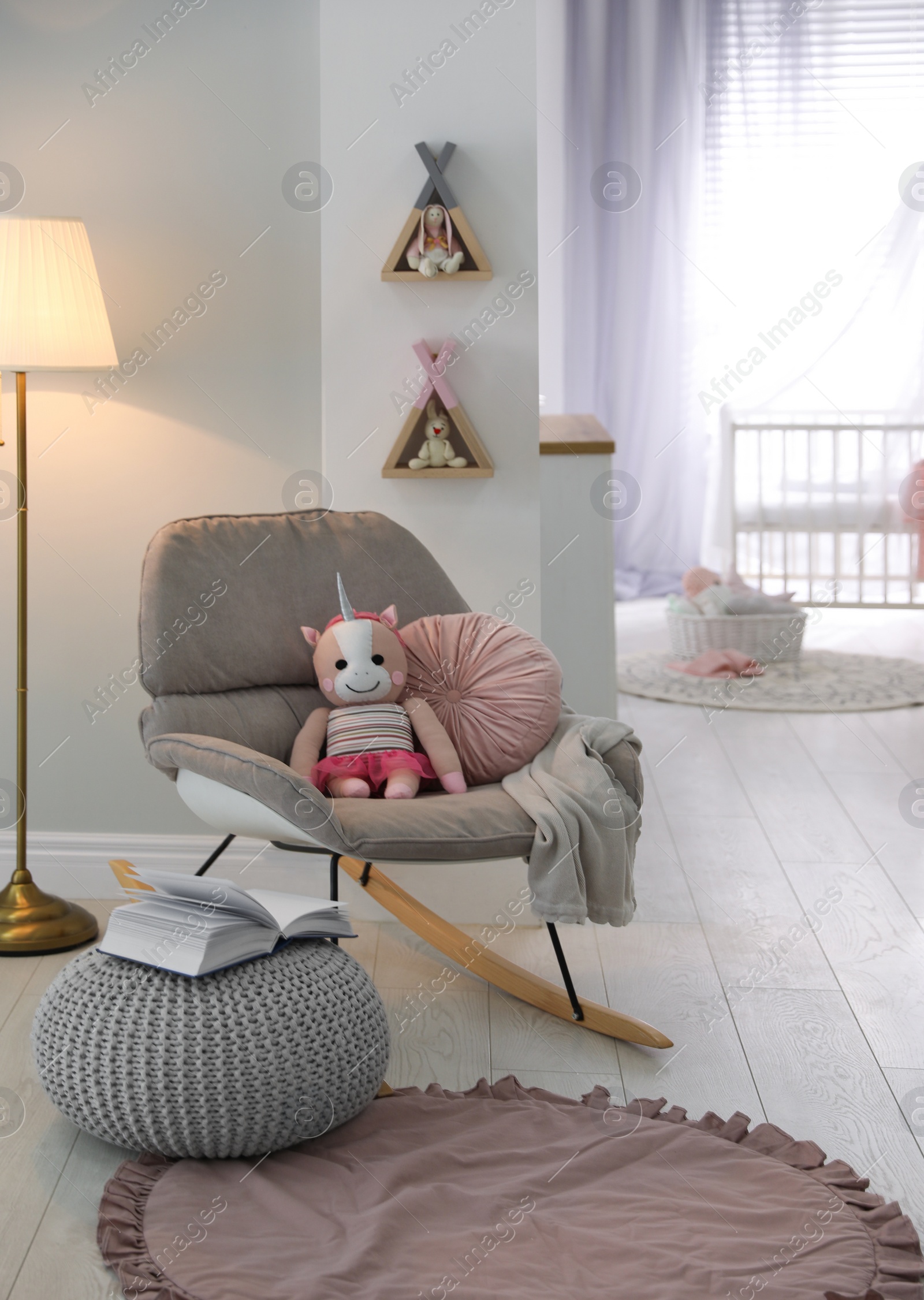 Photo of Cozy baby room interior with comfortable rocking chair