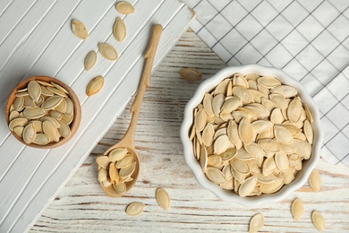 Photo of Flat lay composition with raw pumpkin seeds on white wooden table