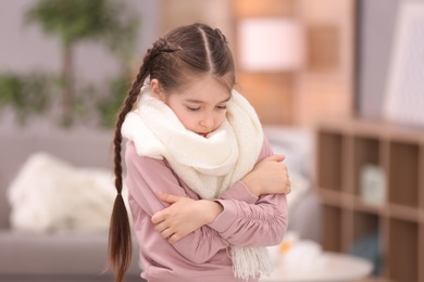 Sad little girl suffering from cold on blurred background