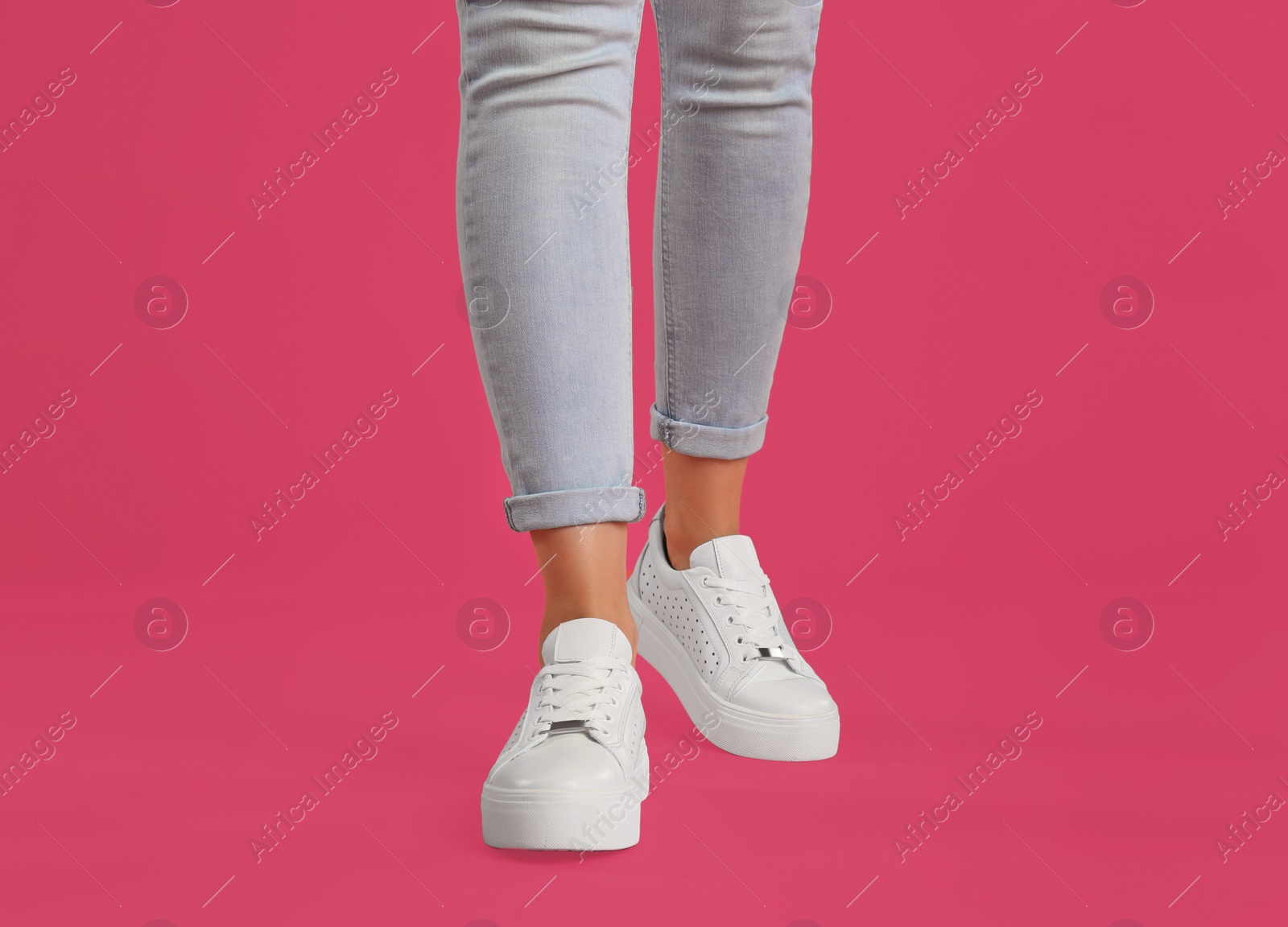 Photo of Woman wearing shoes on pink background, closeup