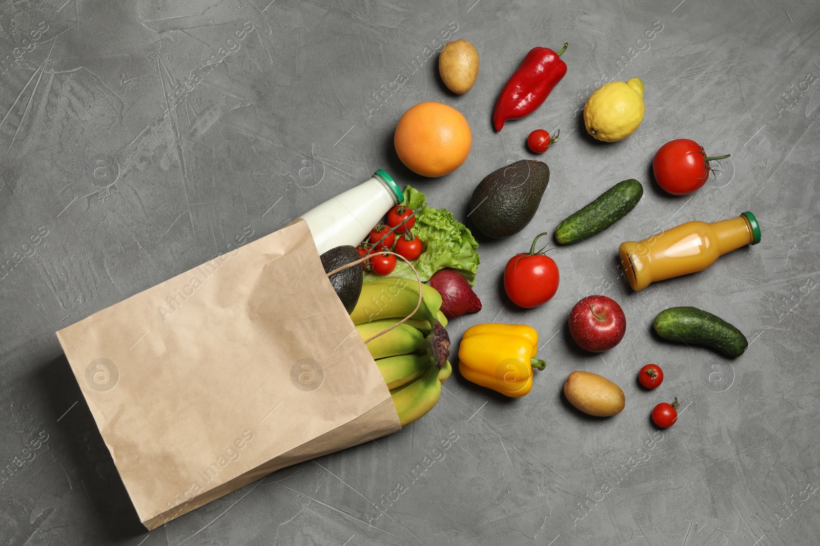 Photo of Paper bag with groceries on grey background, flat lay