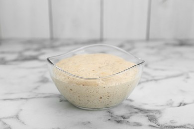 Leaven in glass bowl on white marble table