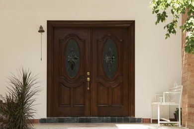 Photo of Wooden doors, bench and plants in private house outdoors