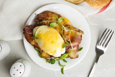 Delicious egg Benedict served on light grey marble table, flat lay