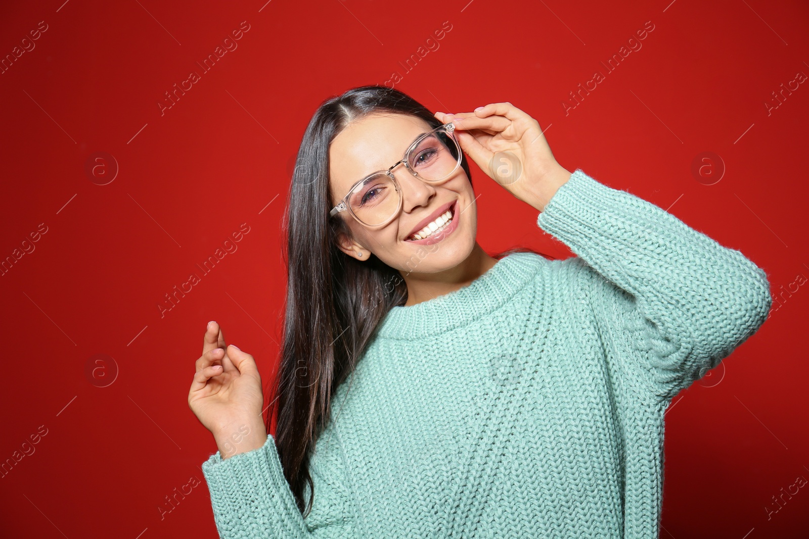 Photo of Young woman in warm sweater on red background