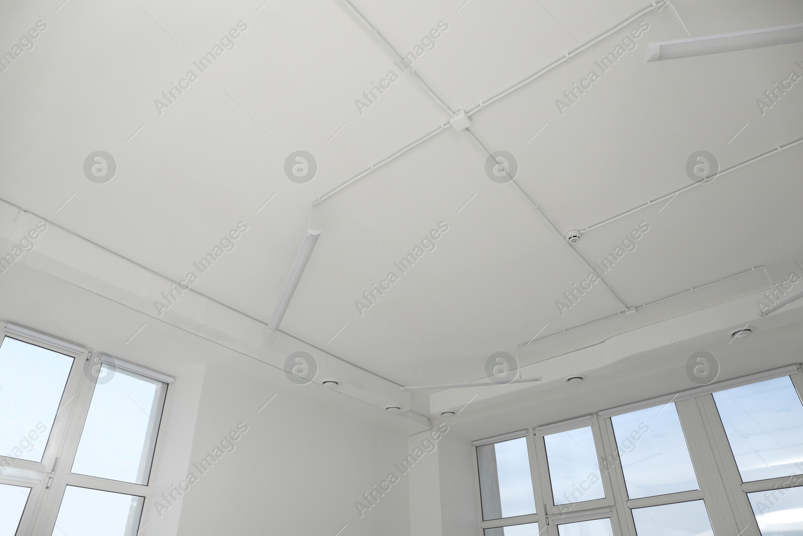 Photo of White ceiling with modern lighting in office