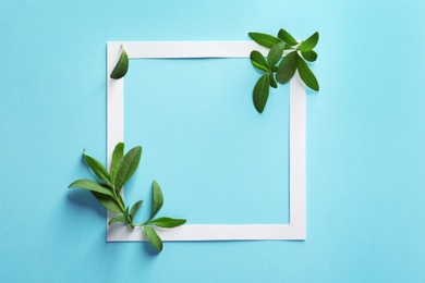 Photo of Frame with green leaves on color background