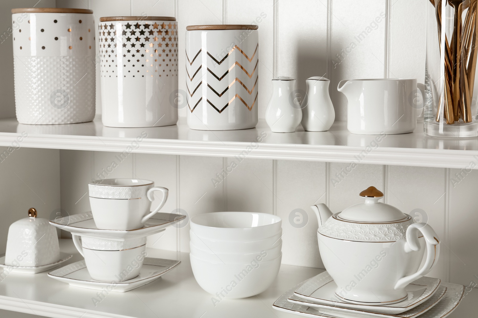 Photo of White shelving unit with set of dishware