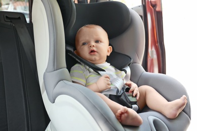 Photo of Little baby in child safety seat inside of car