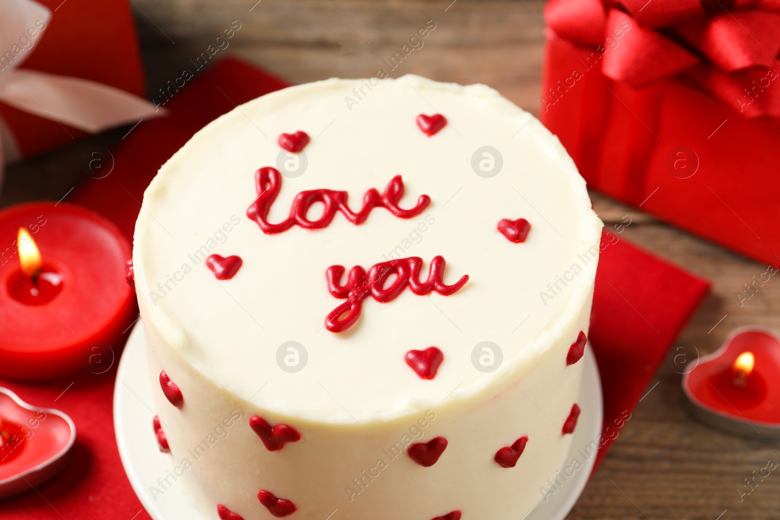 Photo of Bento cake with text Love You and candles on wooden table, closeup. St. Valentine's day surprise