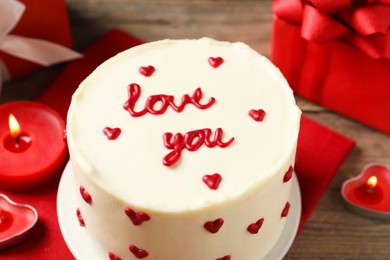 Photo of Bento cake with text Love You and candles on wooden table, closeup. St. Valentine's day surprise