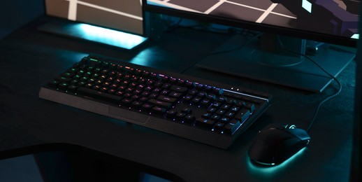 Photo of Playing video games. Computer monitor, keyboard and mouse on table indoors