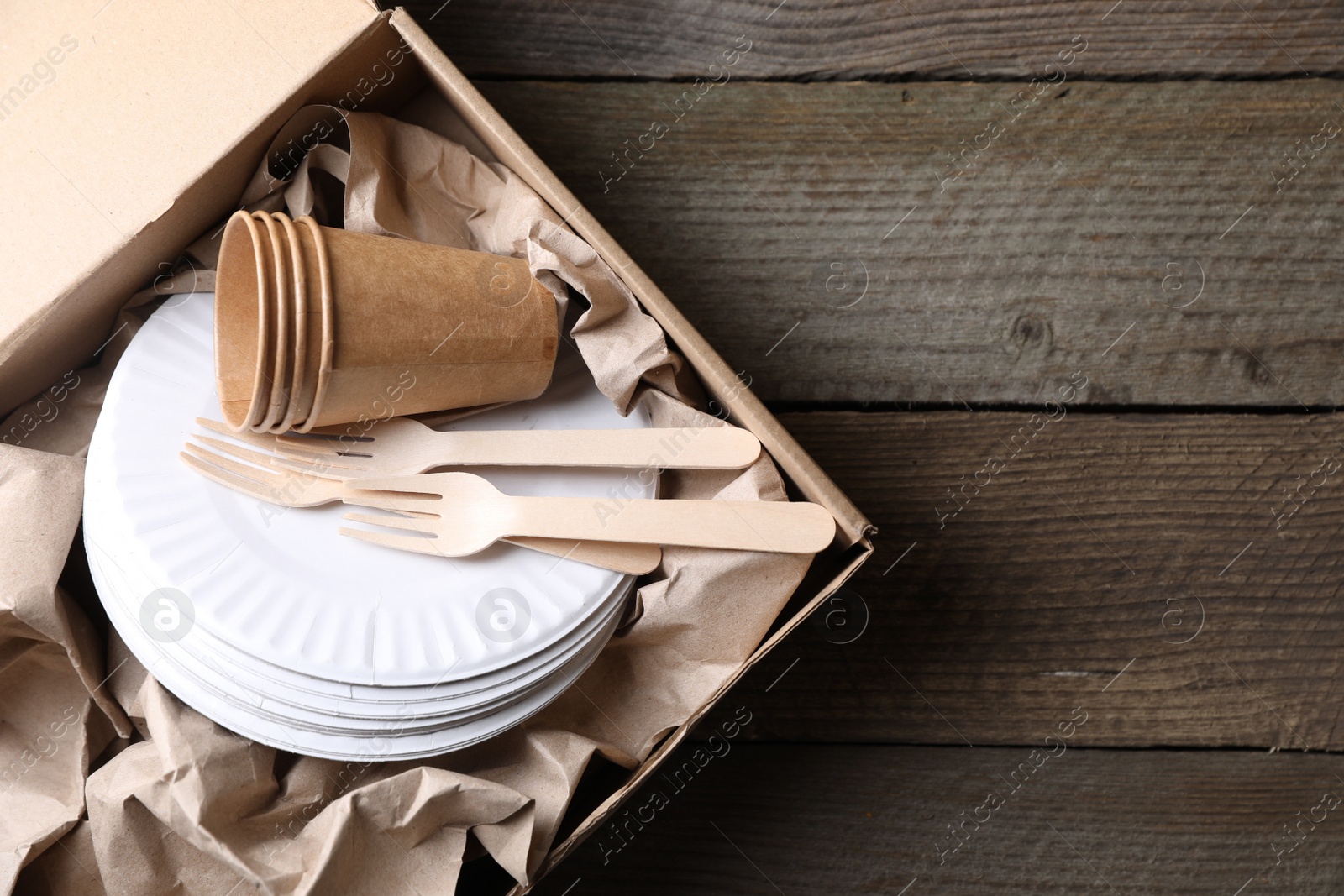 Photo of Box of waste paper on wooden table, top view. Space for text