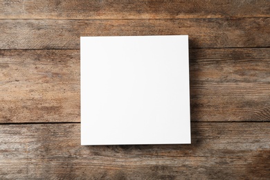 Photo of Stack of blank paper sheets for brochure on wooden background, top view. Mock up