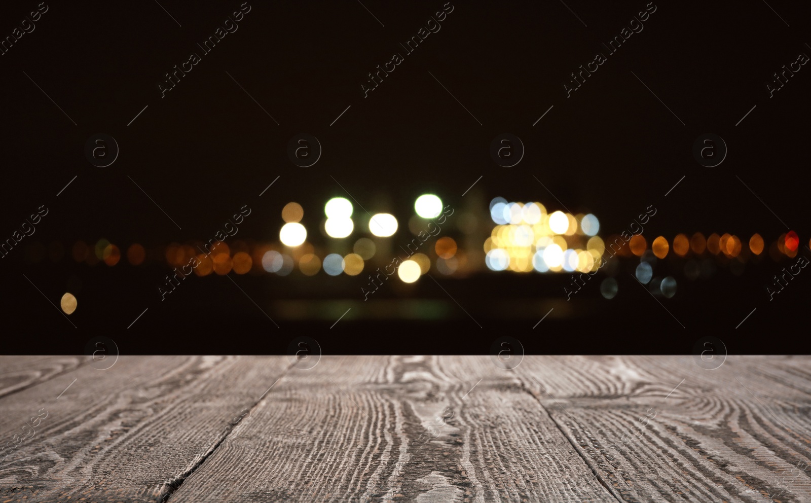 Image of Empty wooden surface against blurred lights. Bokeh effect 