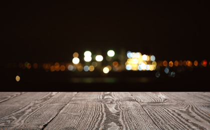 Image of Empty wooden surface against blurred lights. Bokeh effect 