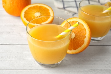 Composition with orange juice and fresh fruit on wooden background