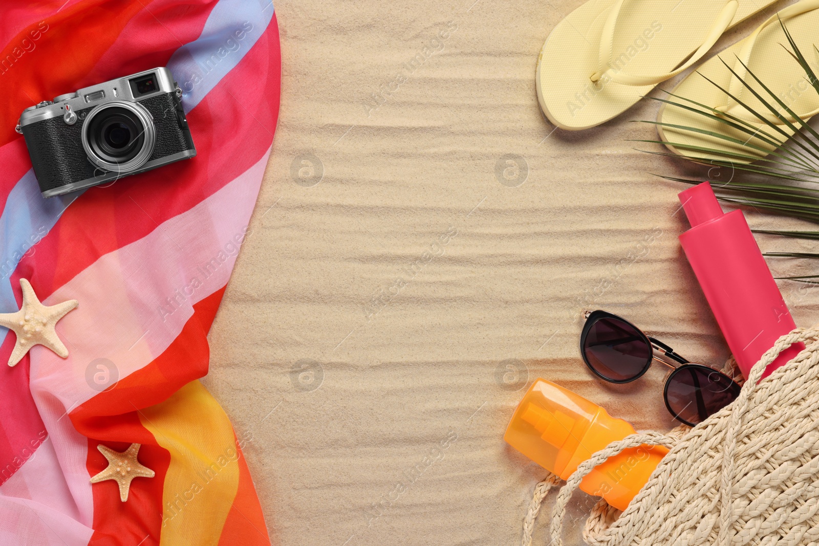 Photo of Flat lay composition with beach accessories on sand, space for text