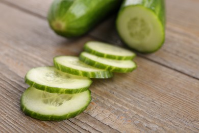 Photo of Cut ripe cucumber on wooden table, closeup