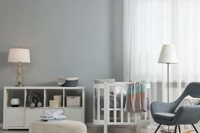 Photo of Newborn baby room interior with stylish furniture and comfortable crib