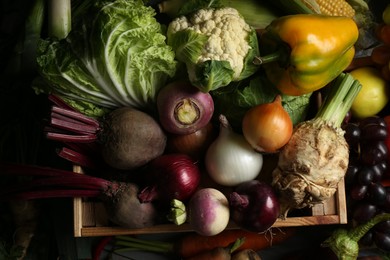 Photo of Different fresh vegetables with wooden crate as background, flat lay. Farmer harvesting