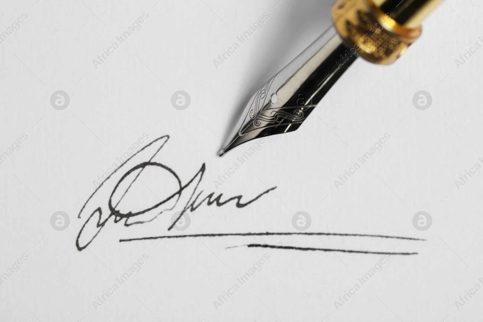 Photo of Signing on sheet of paper with fountain pen, closeup