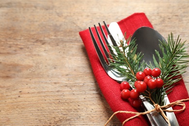 Photo of Cutlery set for festive table on wooden background, closeup. Christmas celebration