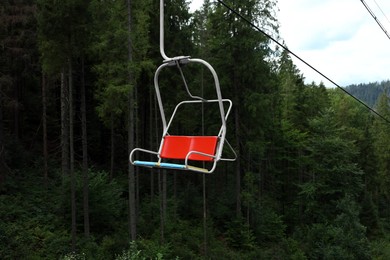 Photo of Empty ski lift and green trees at mountain resort