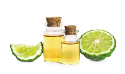 Photo of Bottles of essential oil and fresh bergamot fruit on white background