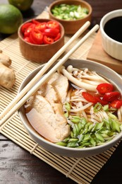 Photo of Delicious ramen with meat and ingredients on wooden table. Noodle soup