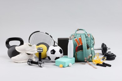 Photo of Many different sports equipment on light grey background