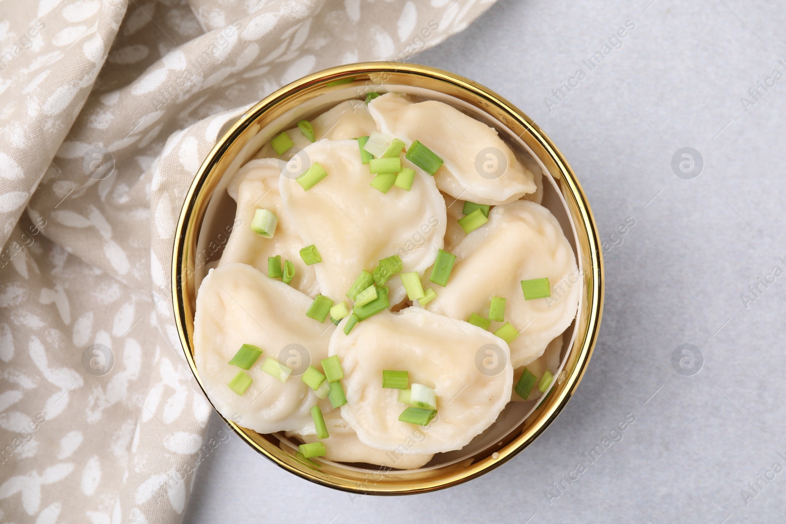 Photo of Cooked dumplings (varenyky) with tasty filling and green onion on light table, top view