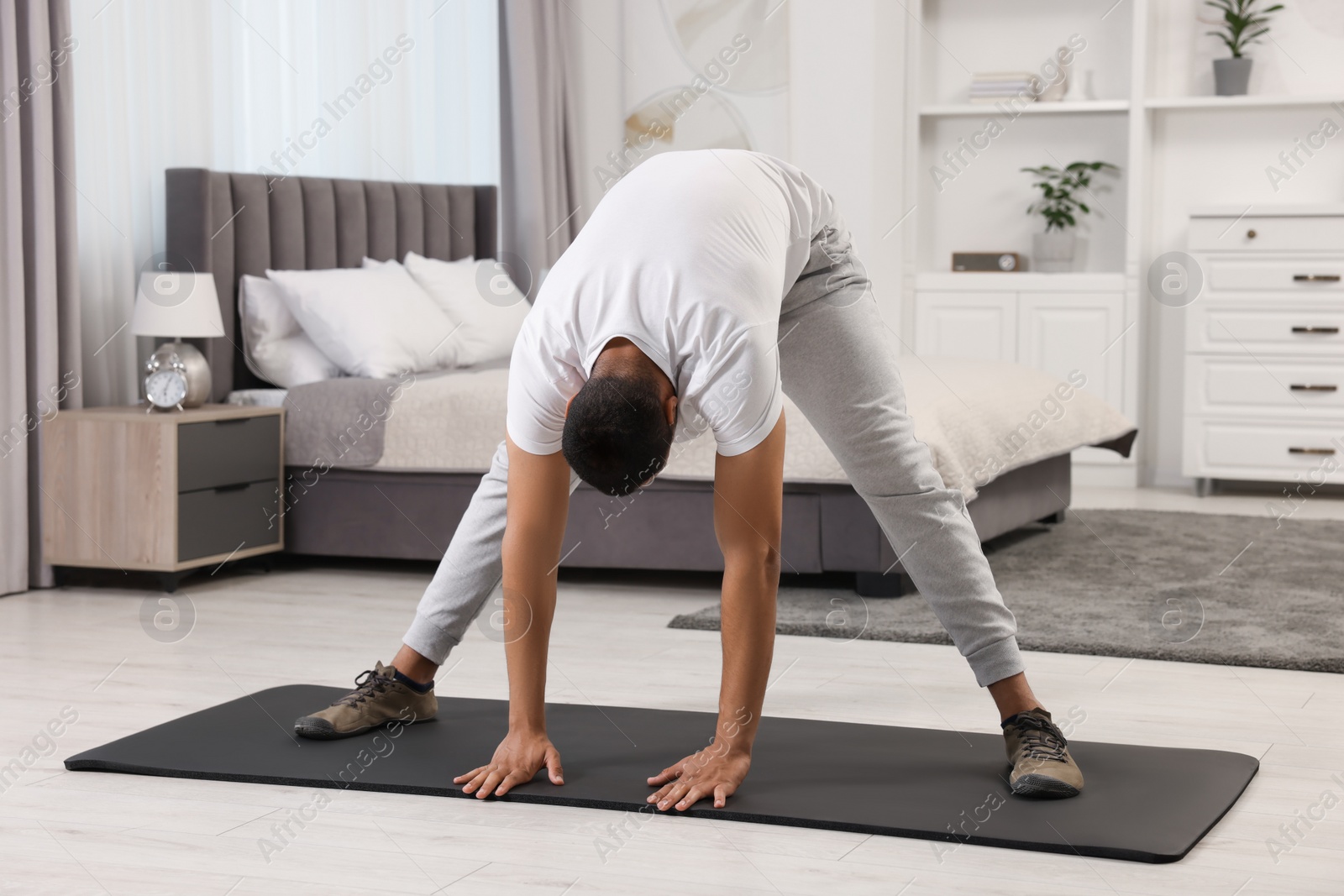 Photo of Man doing morning exercise on fitness mat at home