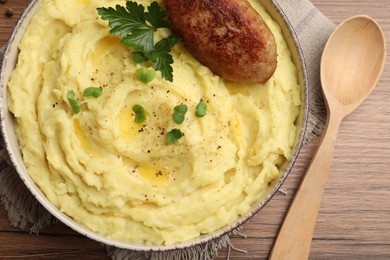 Photo of Bowl of tasty mashed potatoes with parsley, black pepper and cutlet served on wooden table, flat lay